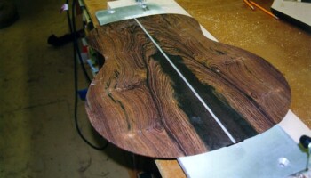 A back lying on the center strip routing template. The template has curved ledges so the back fits precisely in place