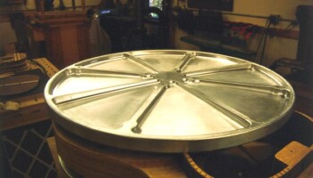 This aluminum dish was machined to be curved with a 15 foot radius. Jim applies sandpaper to it and uses it to true up the sides for receiving the back. This form was made on the Fadal from 1" thick aluminum stock, machined to 1/4" thickness in 8 segments