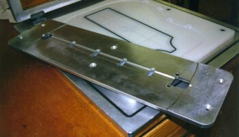 The back is braced with a center strip and several cross braces. The metal plate seen here is a template for routing the back center strip to length and for routing clearance slots for the cross braces