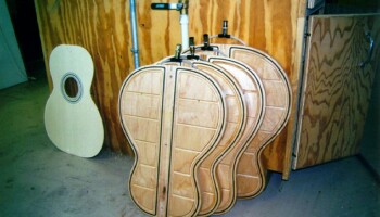 These are templates Jim has used to guide cutting of wood for guitar backs; there is one template for each body size. The wood is held to the template with a vacuum; the black strips are gaskets to seal the vacuum. The templates are oversized by 50 mil to account for later trimming. Top and back cutting is now accomplished with the laser cutter