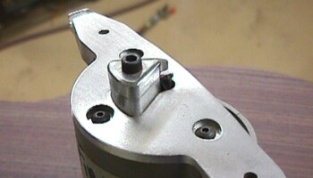 Here the guide has been secured to the router; the router bit is visible protruding through the plate