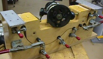 This jig guides a router to trim the sides ("ribs") to the correct length after bending. A rib is mounted and clamped in the jig; then the router is run across the aluminum plate on each end and cuts the end of the rib to a precise length