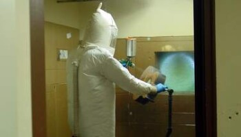 Jim in the spray room. The guitar is held by black pipe mounted to the floor by a flange bearing so it can rotate as needed. Jim thanks Tom Anderson for this great idea!