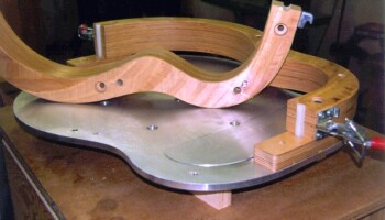 Part of the form that holds the body together as the back and top are glued to the sides. Here the form is open so you can see the plate on the bottom. There is a tapered ledge in this plate; it presses the top against the sides in a manner that maintains the 3/4 degree break angle of the upper bout region